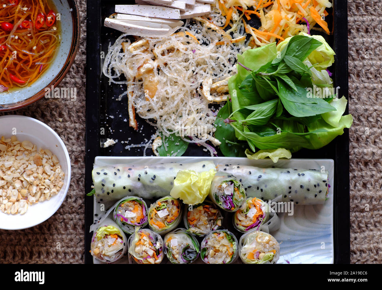 Vue de dessus les rouleaux de papier de riz végétarien en tranches et les rouleaux de printemps vietnamiens, ingrédients légumes colorés faire ce plat végétalien sain et délicieux Banque D'Images