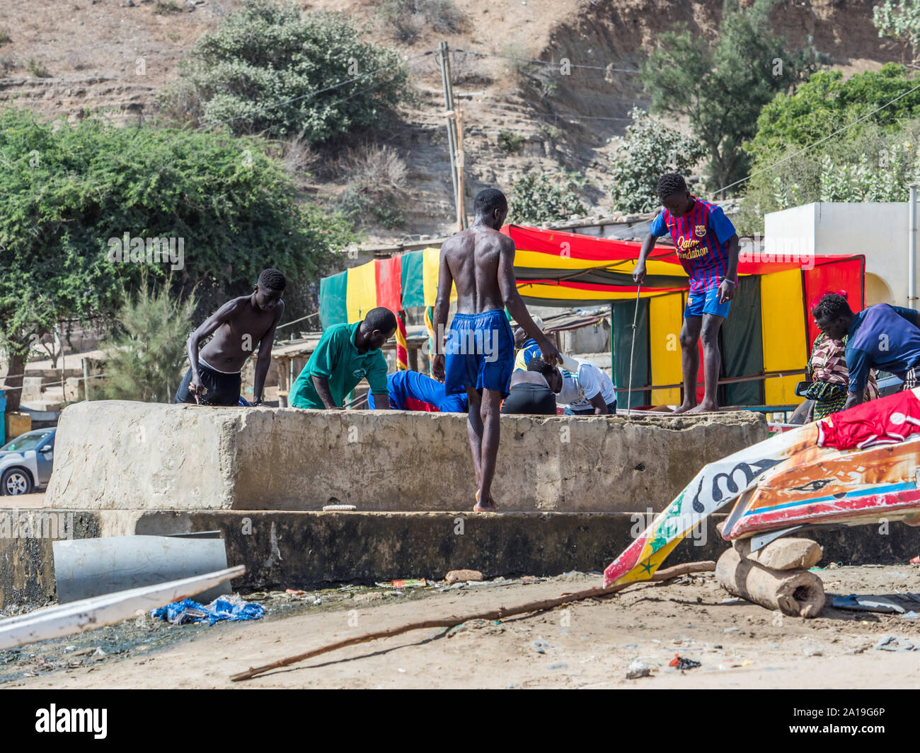Dakar, Sénégal - le 2 février 2019 : garçons africains tirer de l'eau d'un puits dans le village de pêcheurs de Ouakam, près d'une haute falaise, à Dakar, Sénégal Banque D'Images