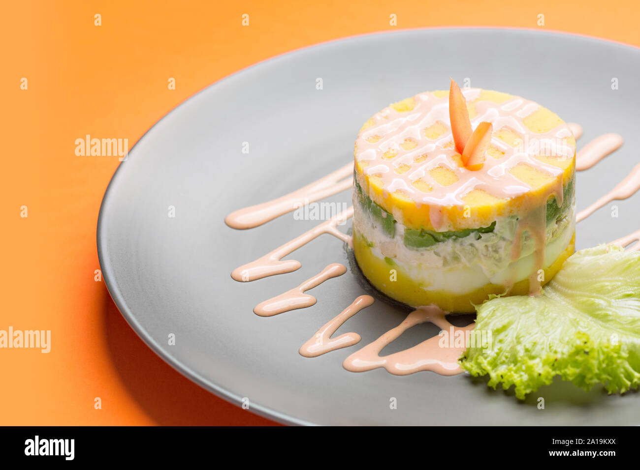 Péruvien traditionnel plat appelé causa faite de purée de piment (AJI) et le jus de lime et remplie de légumes (maïs, pois, carottes) et Banque D'Images