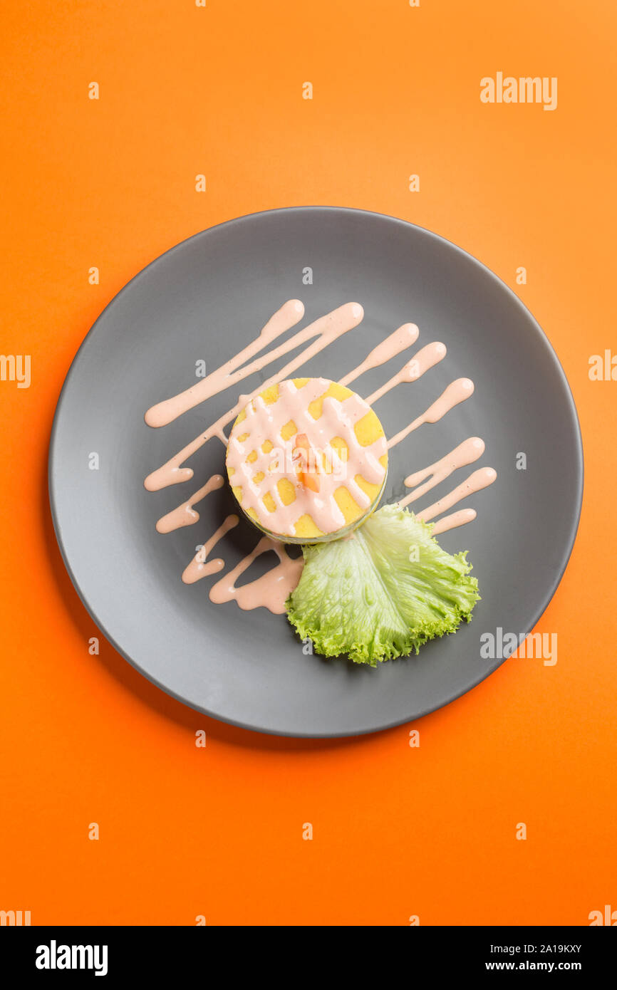 Péruvien traditionnel plat appelé causa faite de purée de piment (AJI) et le jus de lime et remplie de légumes (maïs, pois, carottes) et Banque D'Images