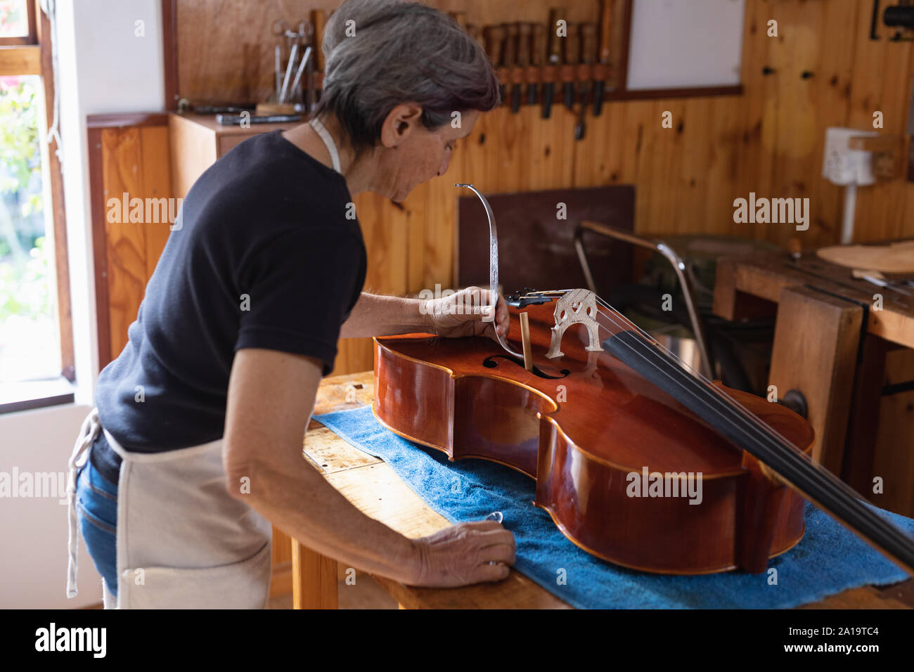 Luthier féminin au travail dans un atelier Banque D'Images