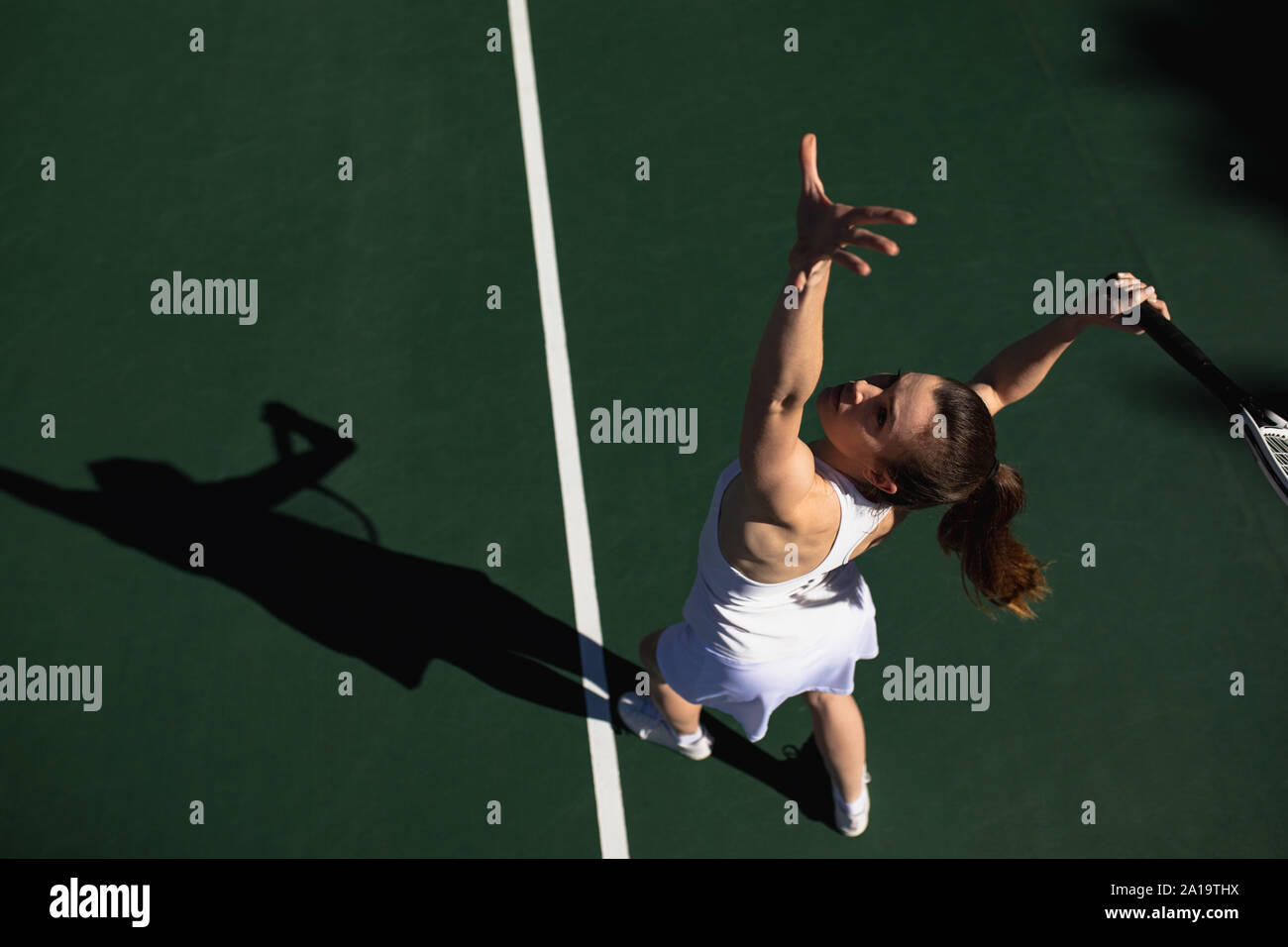 Femme jouant au tennis sur une journée ensoleillée Banque D'Images