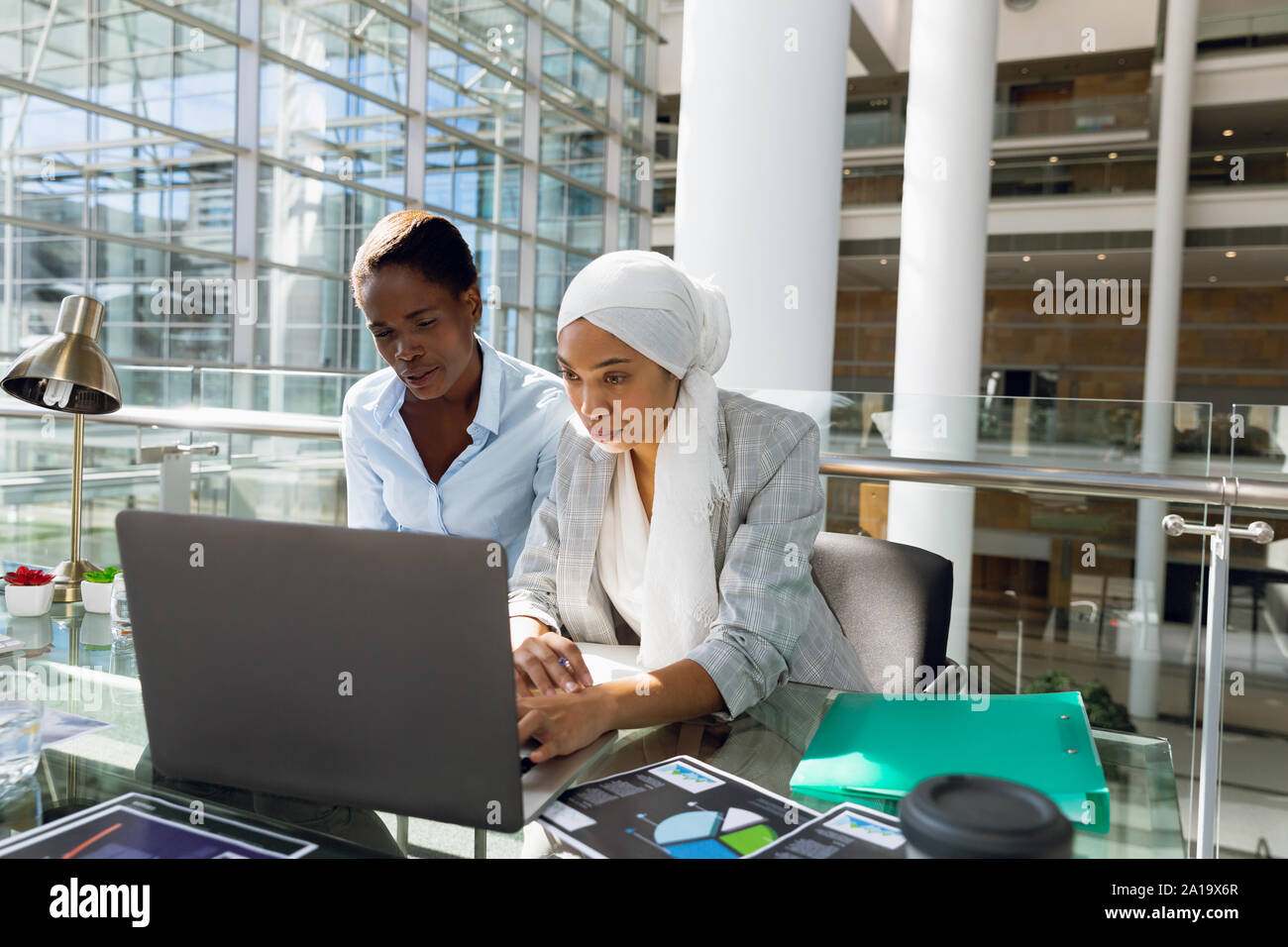Les femmes cadres travaillant ensemble sur laptop at desk Banque D'Images