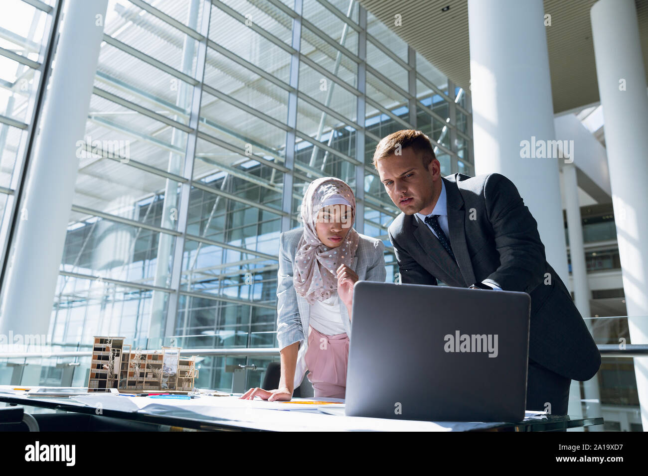 Hommes et femmes architectes discussing over laptop in office Banque D'Images