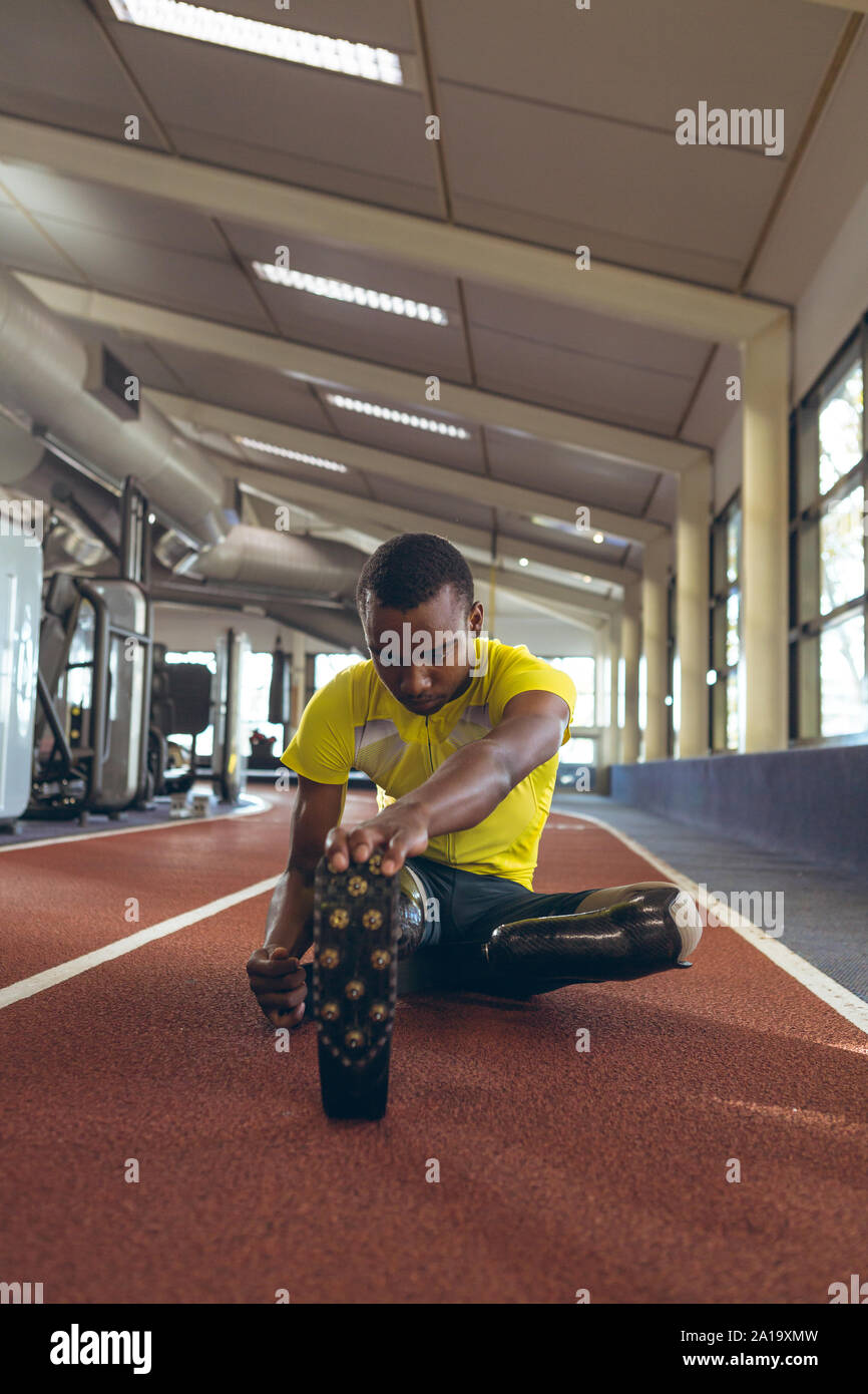 Mobilité African American male athletic exerçant sur une piste de course dans le centre de remise en forme Banque D'Images