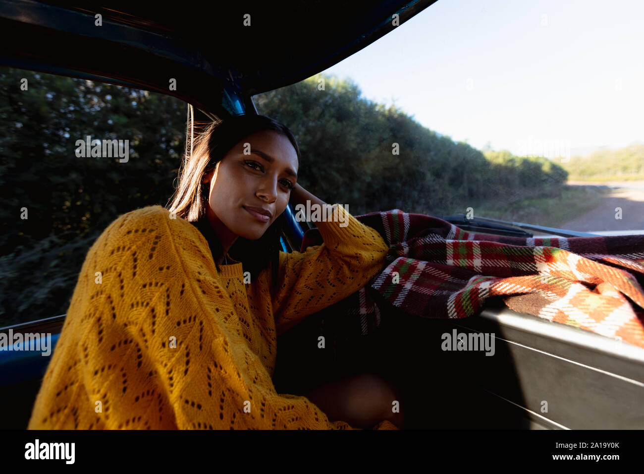 Jeune femme se détendre dans une camionnette pendant un voyage sur la route Banque D'Images