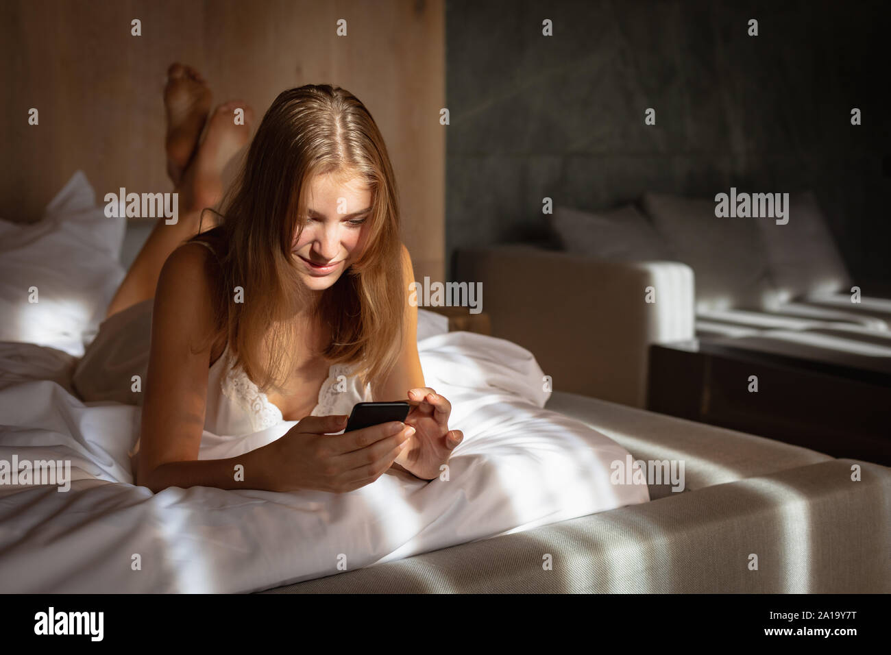 Jeune blonde woman using smartphone Banque D'Images