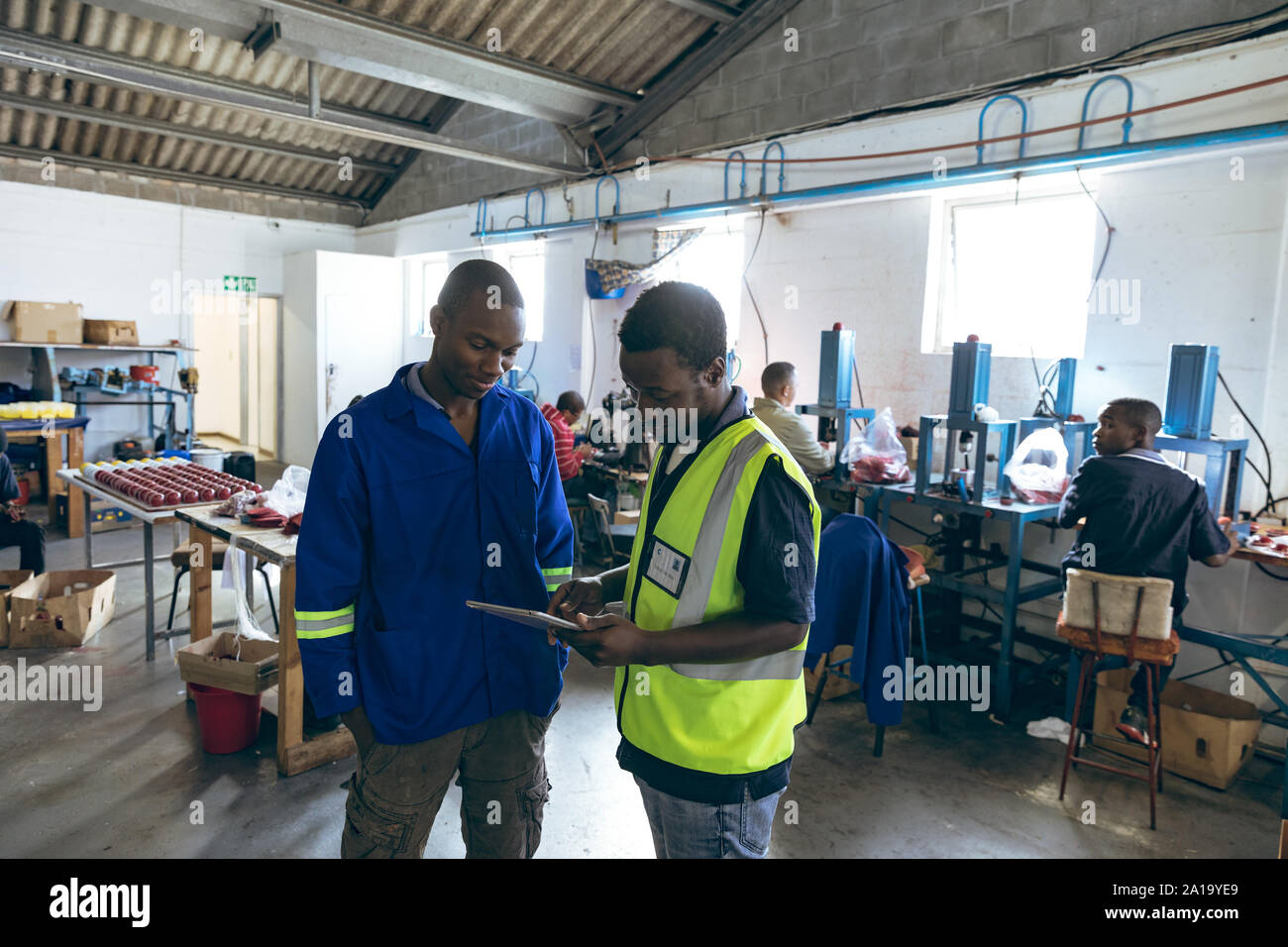 Les jeunes hommes et de travail en utilisant le comprimé dans une usine d'équipement de sport Banque D'Images