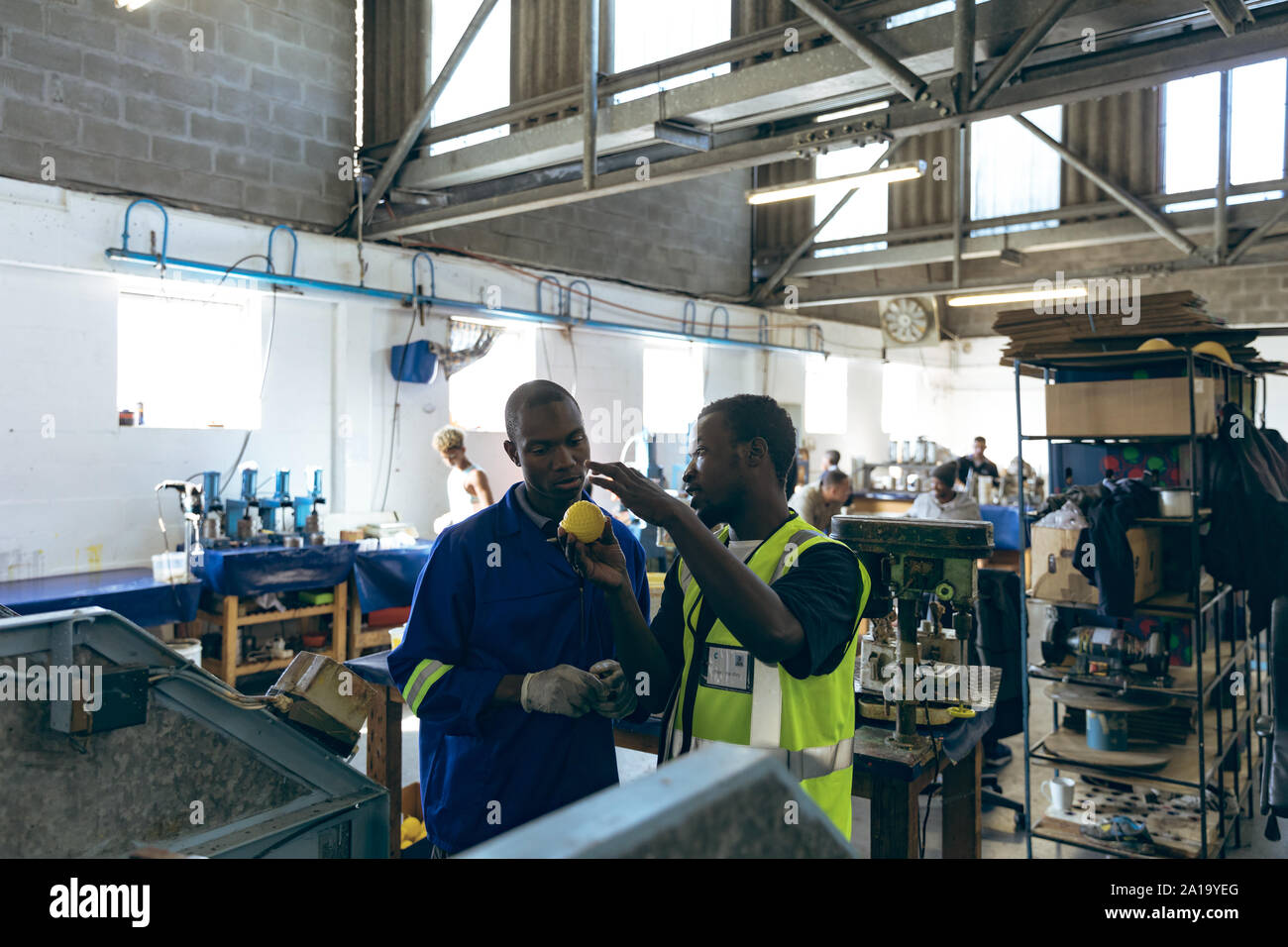 Deux hommes travaillant ensemble dans une usine d'équipement de sport Banque D'Images