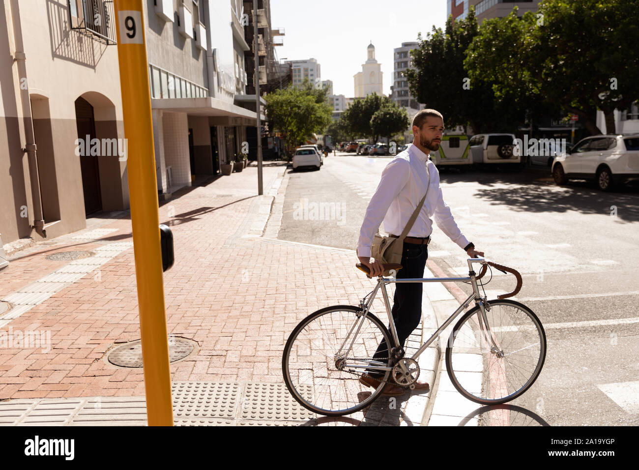 Jeune professionnel homme debout avec un vélo Banque D'Images