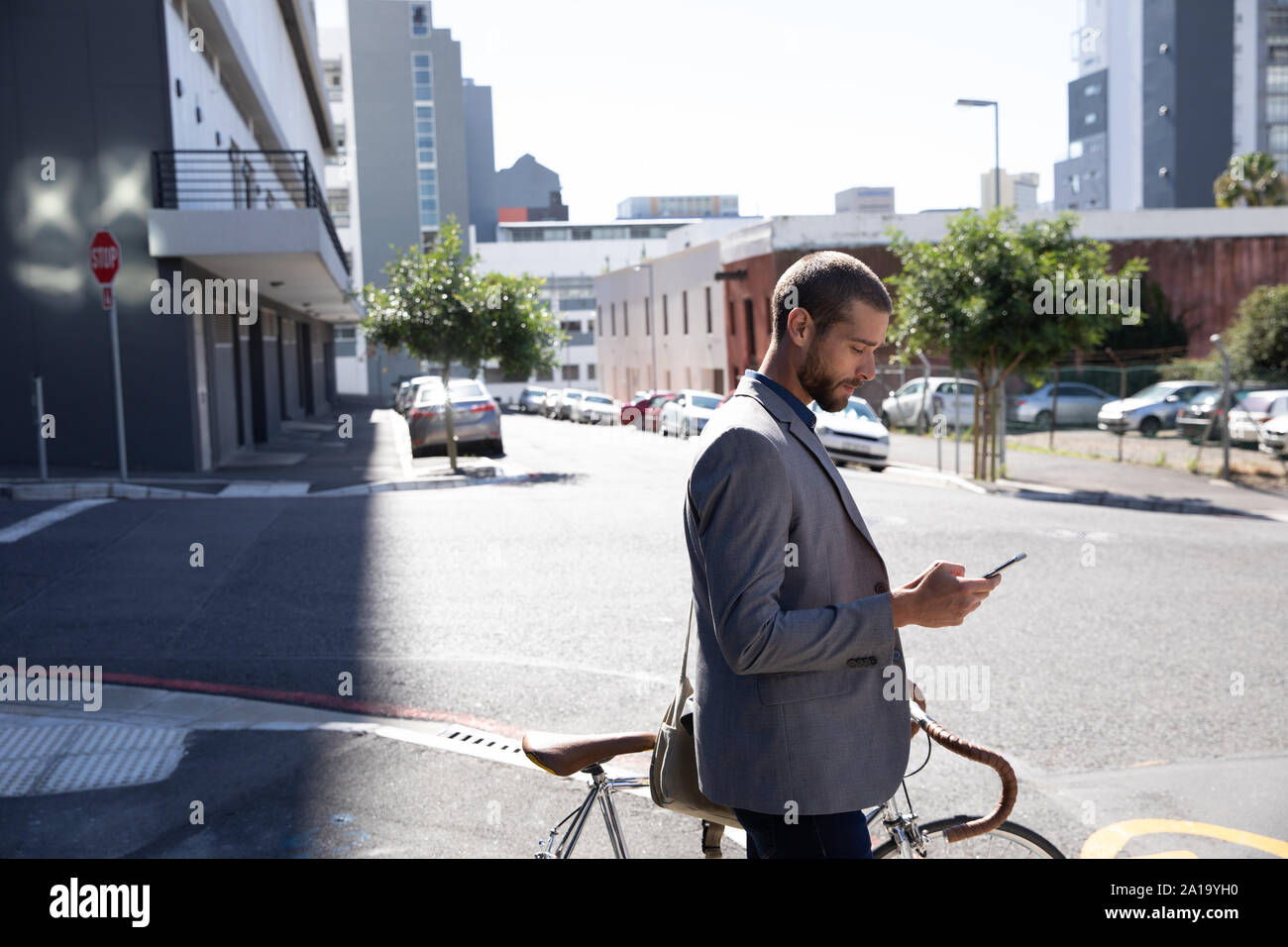 Young man using smartphone et la tenue d'un vélo Banque D'Images