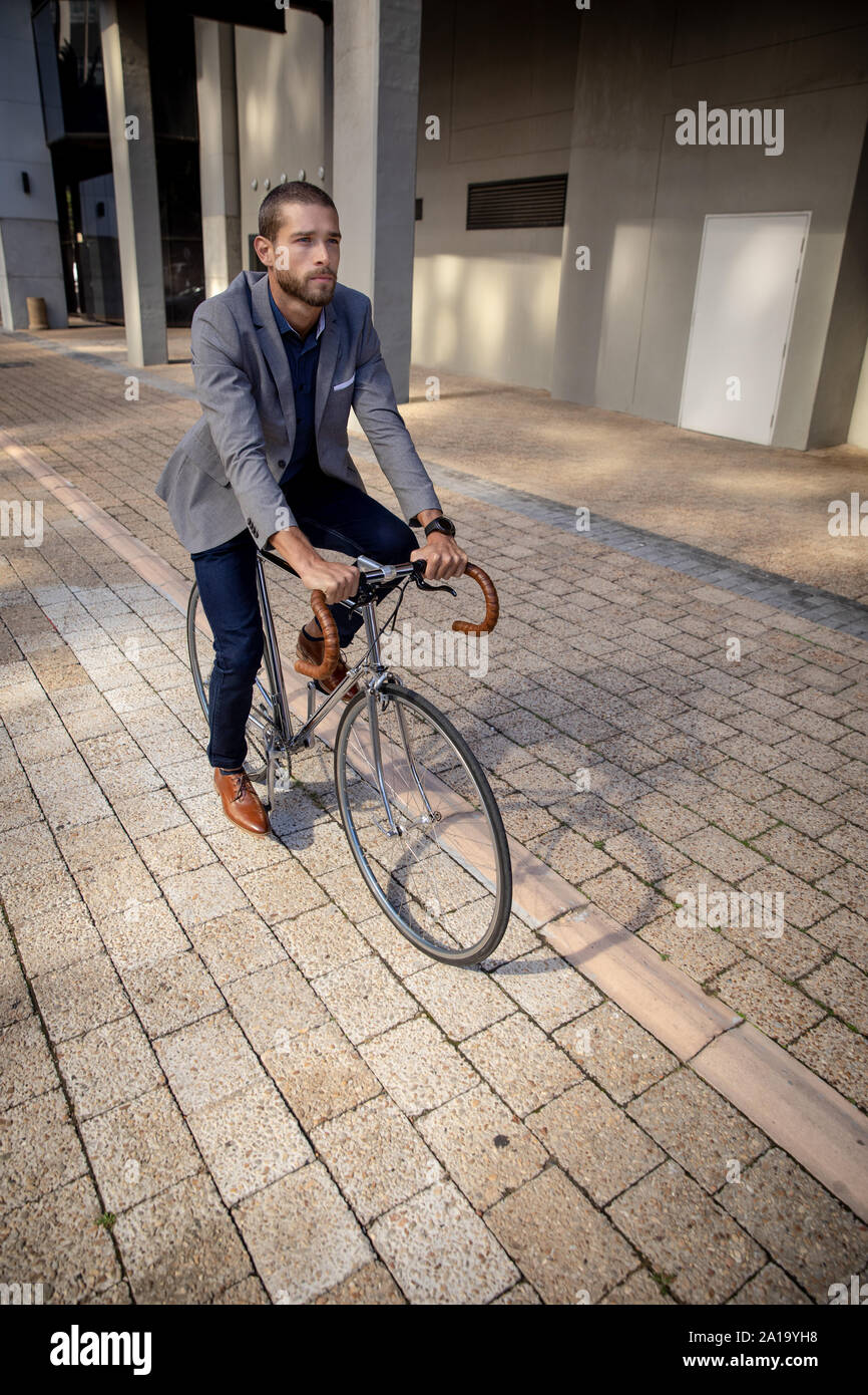 Jeune homme professionnel rouler à vélo dans une ville Banque D'Images