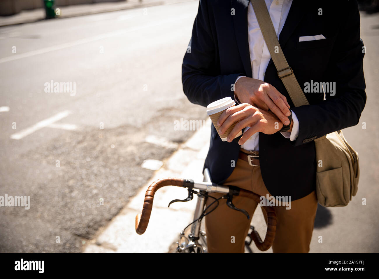 Jeune homme professionnel Contrôle de temps et assis sur un vélo Banque D'Images