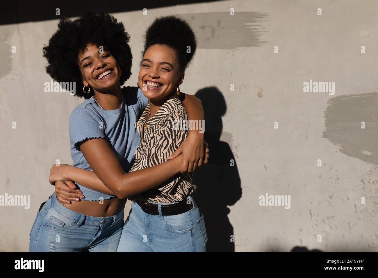 Deux jeunes femmes embracing outdoors Banque D'Images
