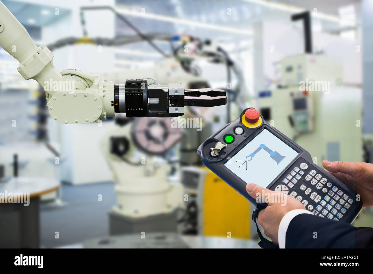 Ingénieur avec télécommande d'appareil. Robot de programmation avec bras robotique. Smart factory Banque D'Images