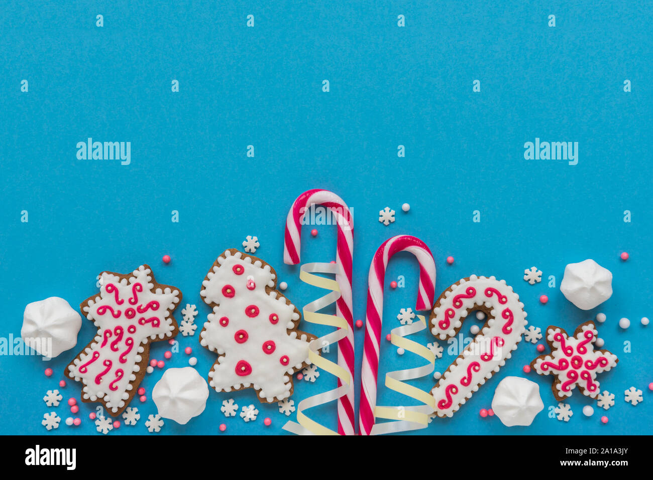 Décorations de Noël, des biscuits au gingembre et des cannes de bonbon et de meringues sur fond bleu Banque D'Images