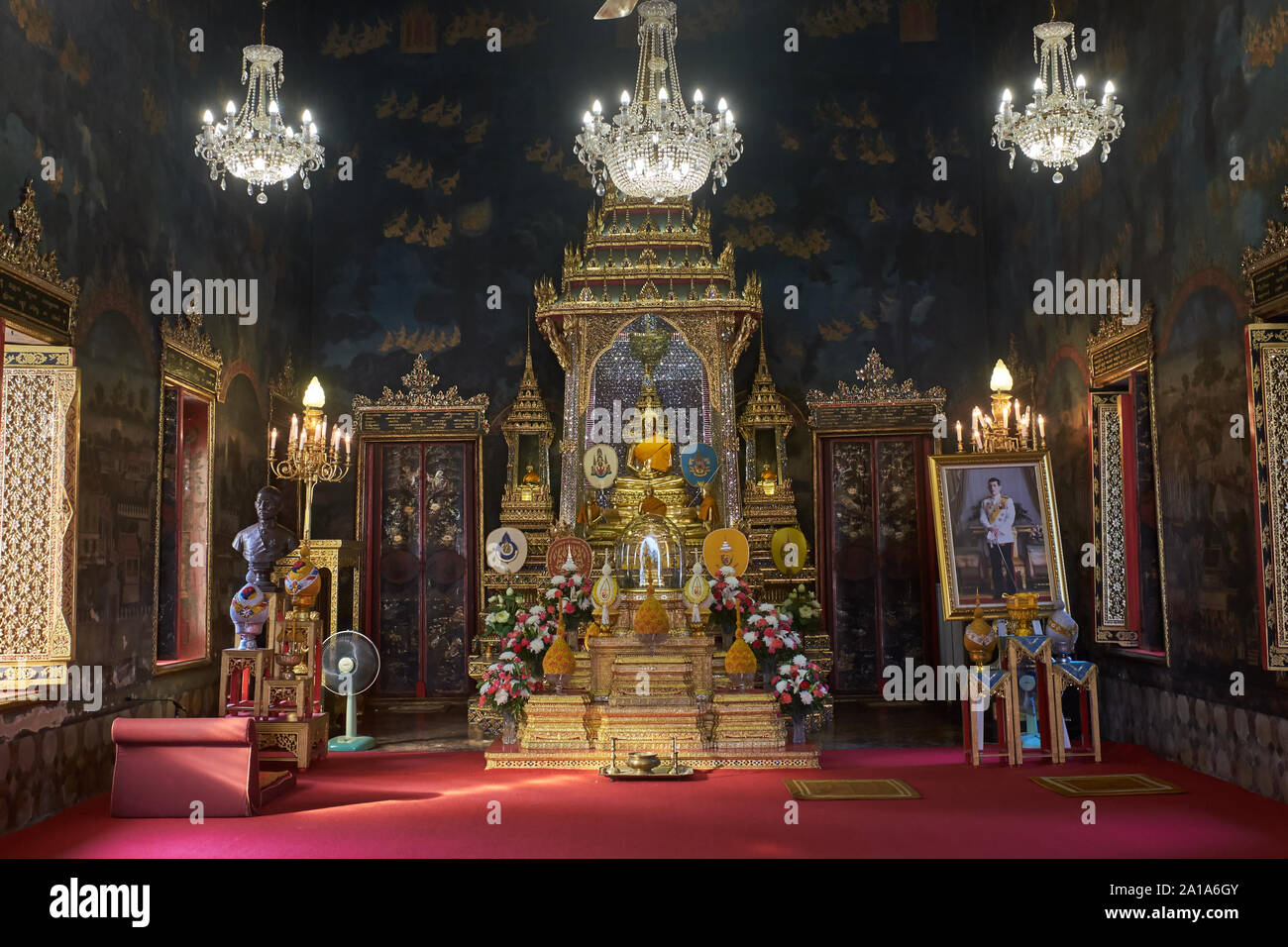 Une prière de culte sous des lustres dans Wat Rajapradit, Bangkok, Thaïlande, avec une statue de Bouddha et un portrait de roi thaïlandais Maha Vajiralongkorn (r) Banque D'Images