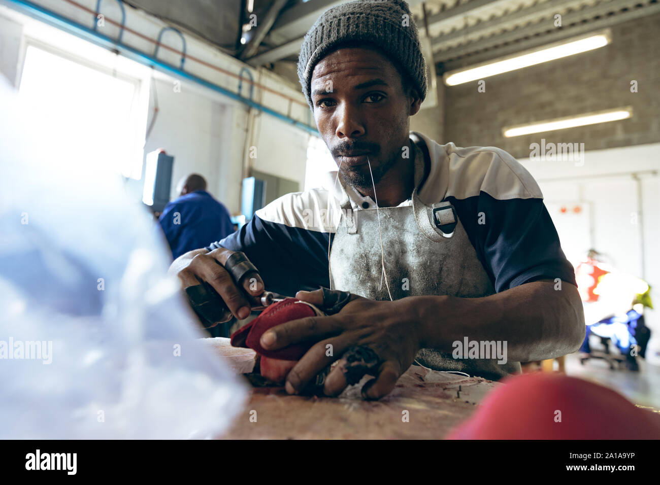 Jeune homme travaillant dans une usine d'équipement de sport Banque D'Images