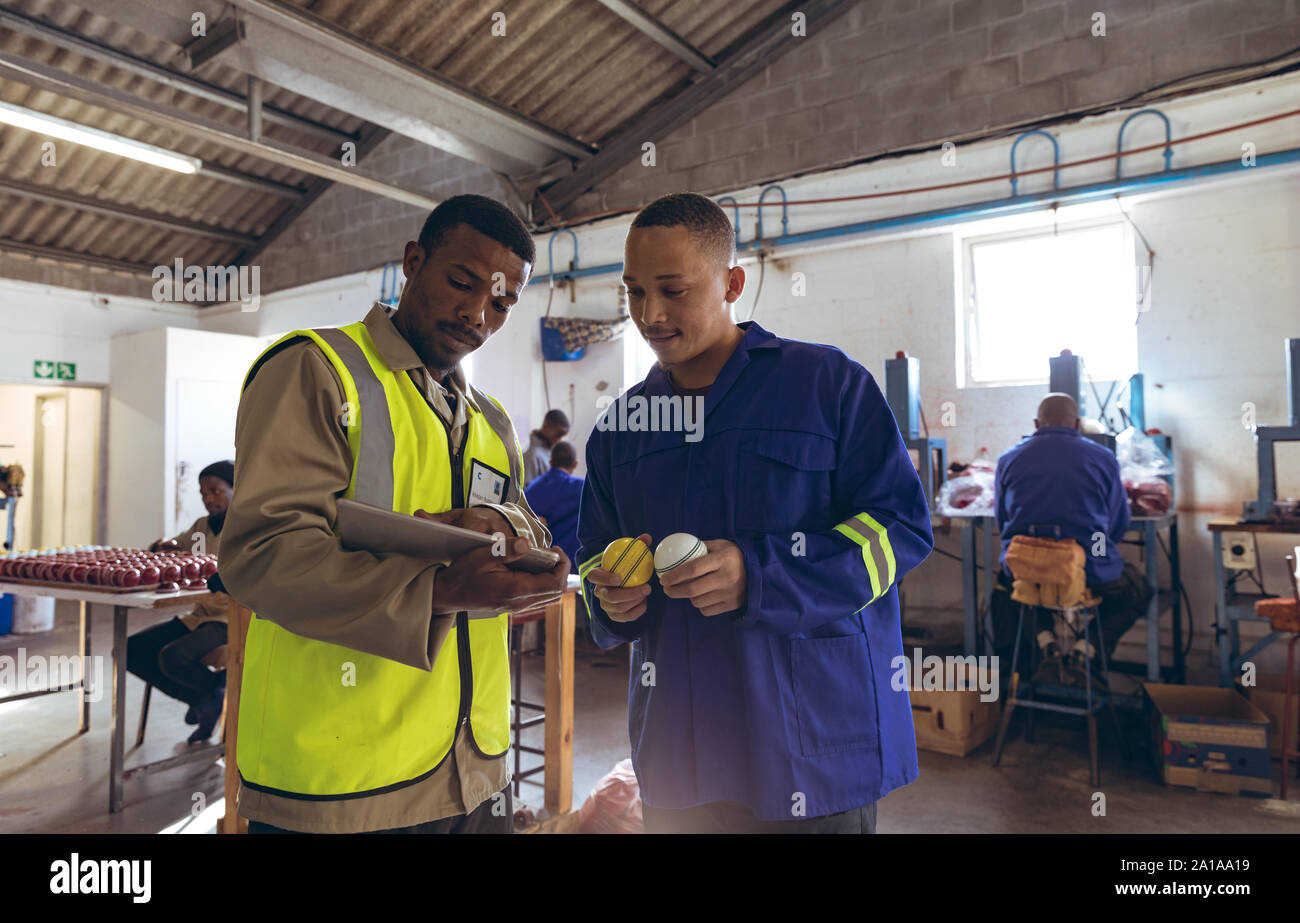 Les jeunes hommes et de travail à l'aide de comprimé à la fabrique de l'équipement de sport Banque D'Images