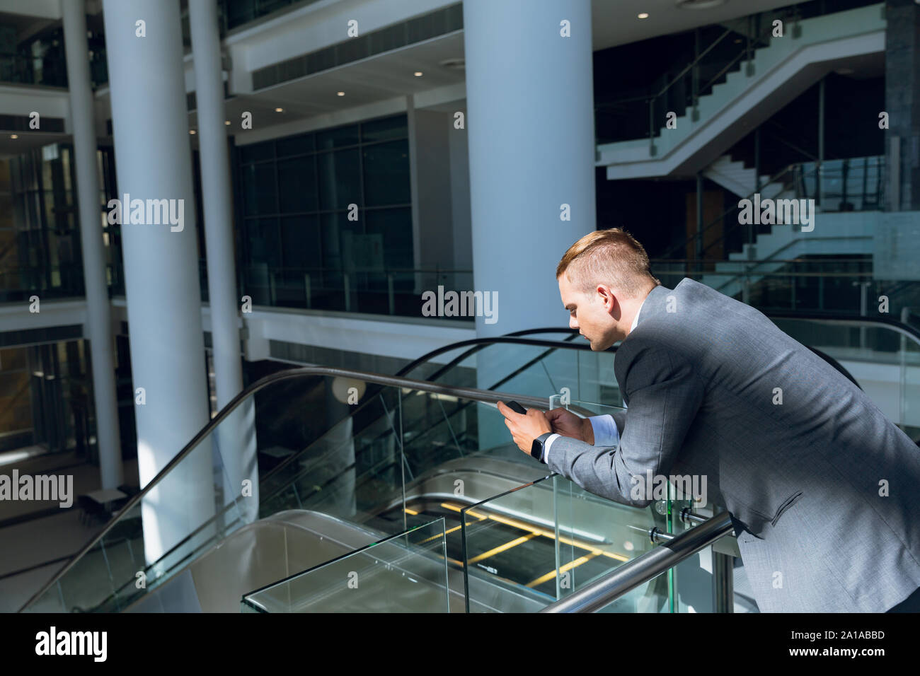 Businessman using mobile phone dans le couloir Banque D'Images