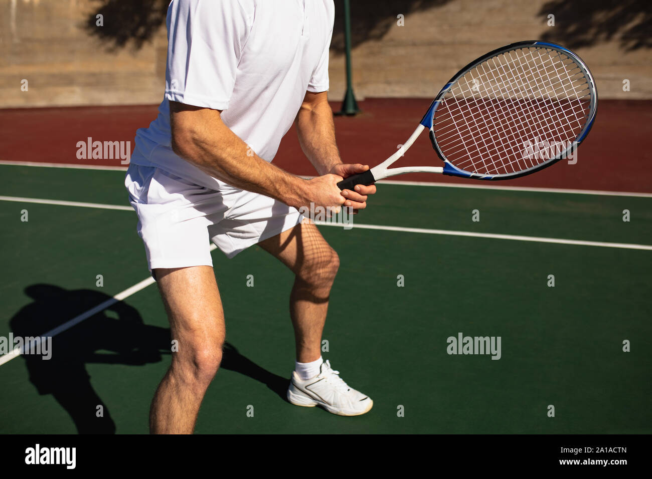 L'homme jouant au tennis sur une journée ensoleillée Banque D'Images