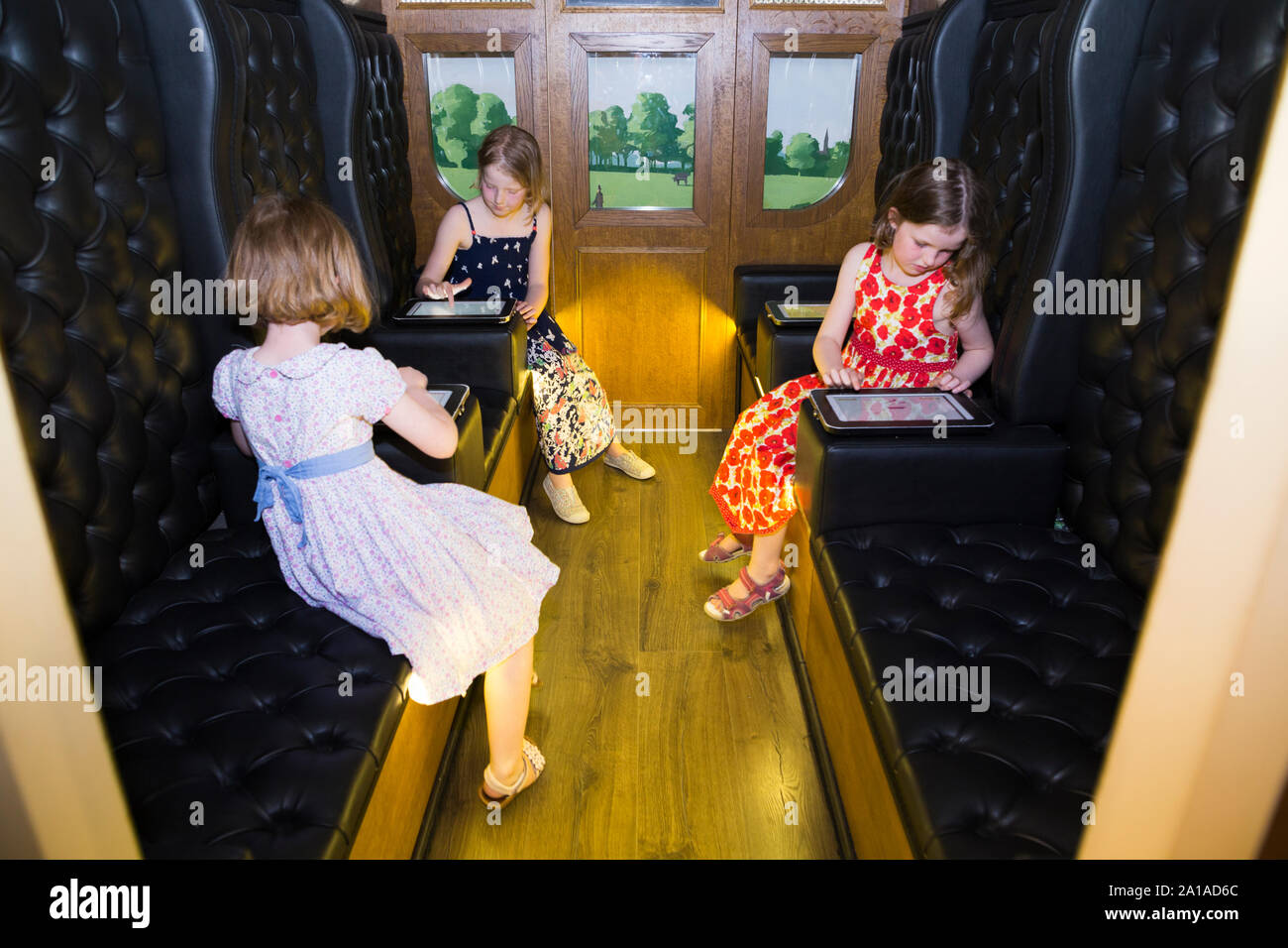 Trois enfants / Enfants / enfant / kid soeurs en écran interactif railway carriage, faire l'expérience de début de trajet en train et effectuer une tâche / dessiner un cercle au cours d'un voyage mouvementé dans un wagon de chemin de fer à voie large, comme Brunel avait initialement fait, au cours de l'exposition, qui accompagne le Brunel SS Great Britain ship, arsenal, à Bristol. Royaume-uni (109) Banque D'Images