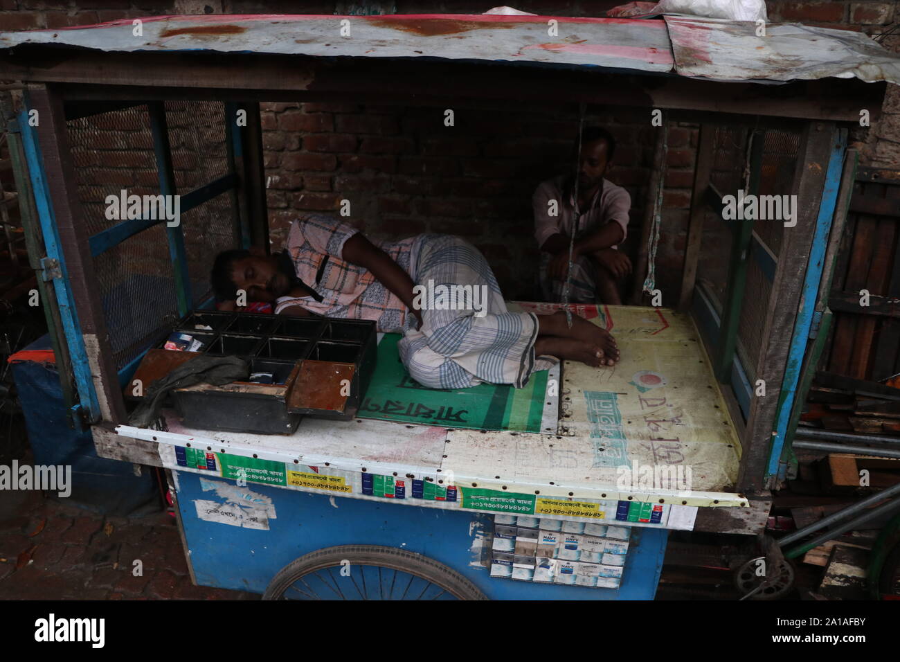 bangladeshi shopkeepe 25sep2019.par temps humide, le commerçant dort paisiblement© Nazmul Islam / alamy Live news Banque D'Images