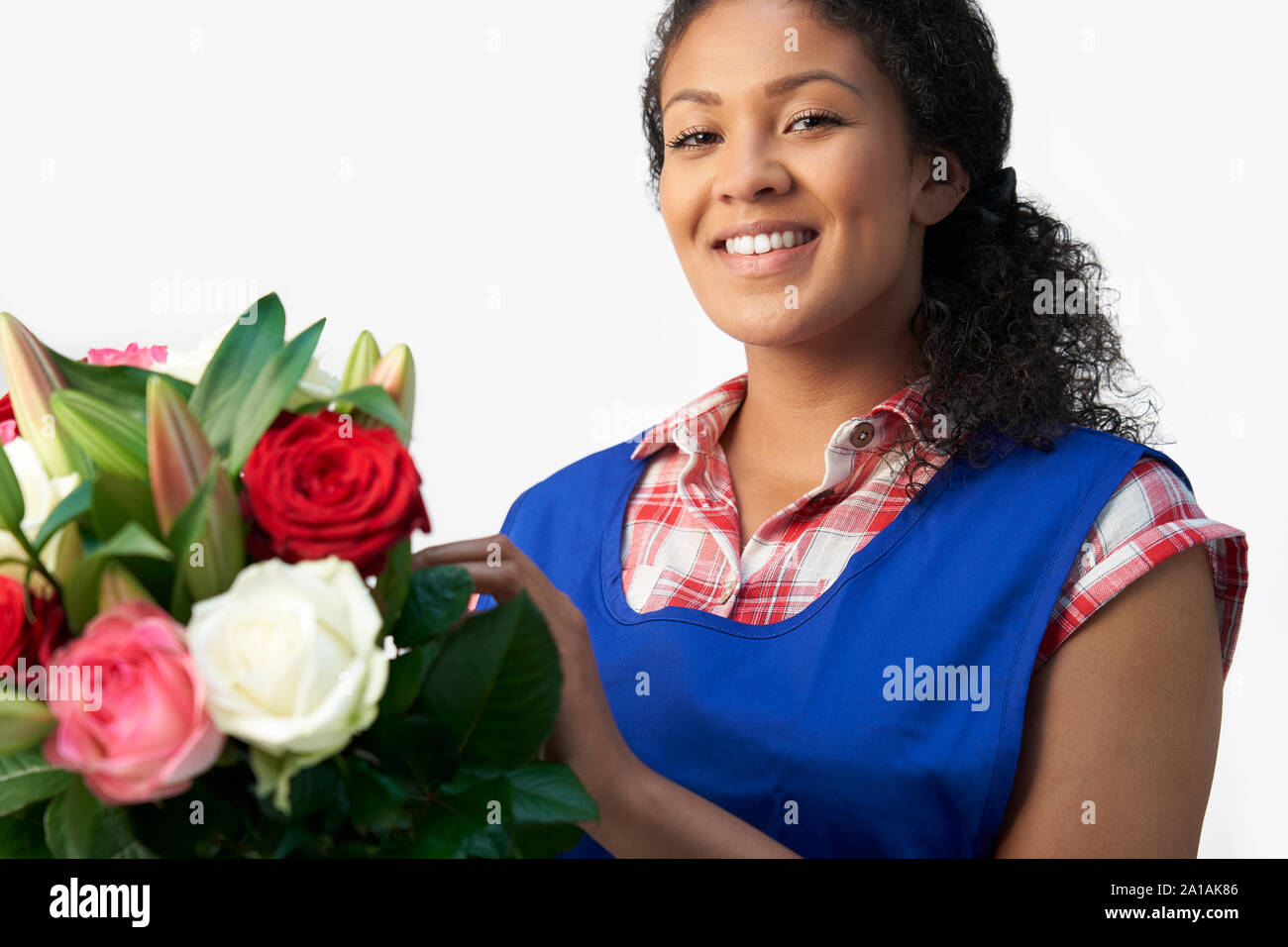 Portrait of Female Florist Organisation Bouquet de roses et Lys Against White Background Banque D'Images