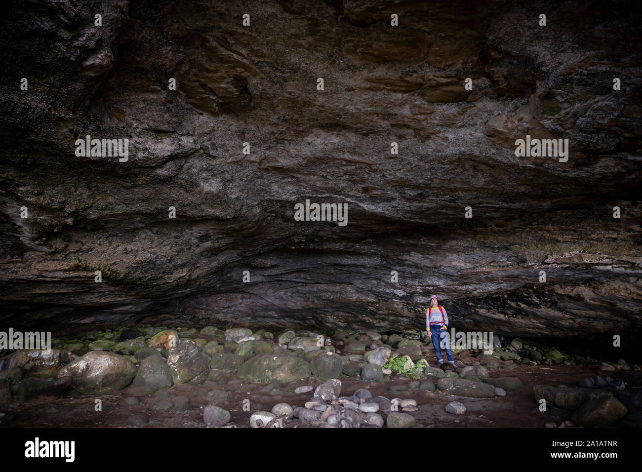 Femme debout dans la grande caverne sur arran Banque D'Images