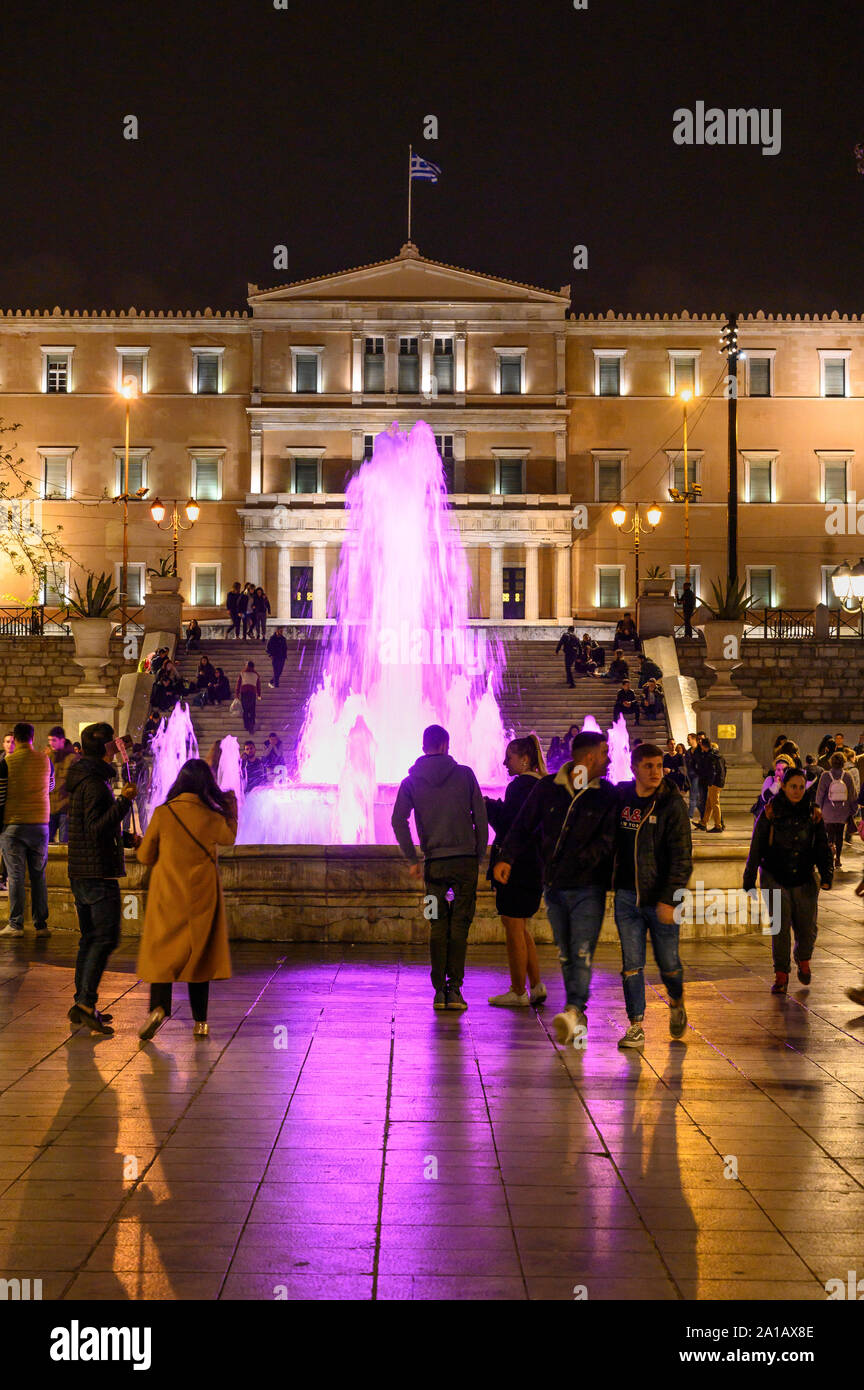 Profitant de la foule une promenade en soirée dans la place Syntagma à la Vouli, le parlement grec, dans l'arrière-plan, d'Athènes, Grèce. Banque D'Images