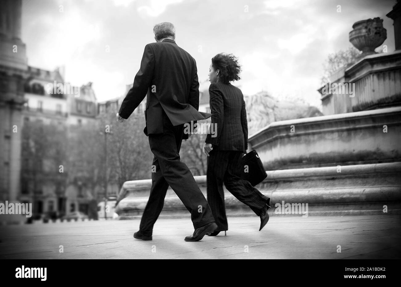 Businesspeople walking à côté d'une fontaine. Banque D'Images