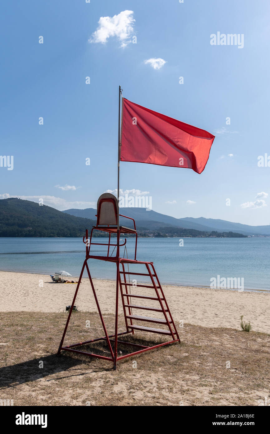 Chaise de sauveteur de brandir le drapeau rouge. Pas de piscine concept. Plage de Galice, Espagne Banque D'Images