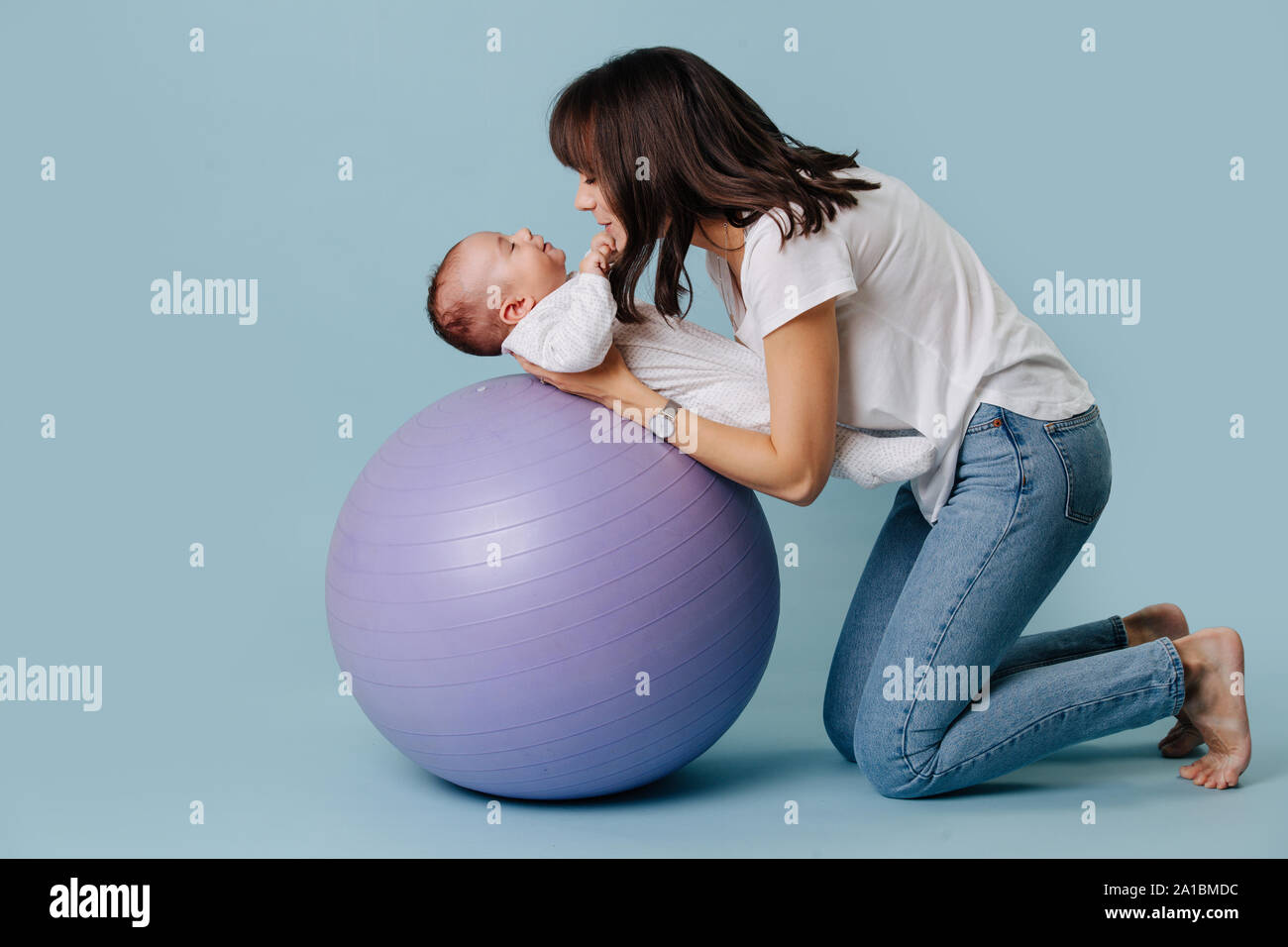 Heureux De Faire Les Exercices De La Mere Avec Son Nourrisson Enfant Bebe Sur Balle De Yoga Violet Photo Stock Alamy