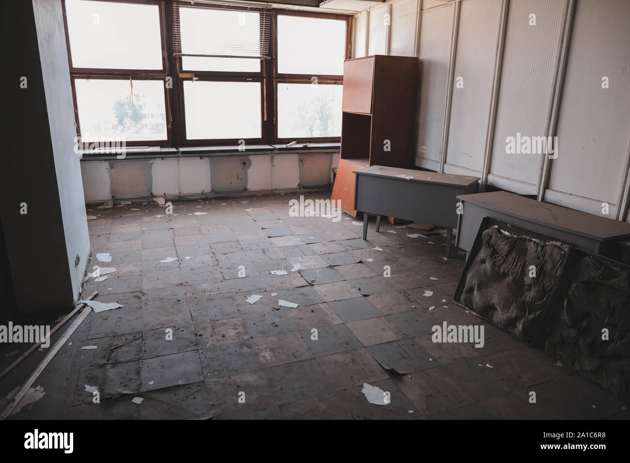 Dirty chambres vides, avec des fenêtres cassées et des meubles, dans un bâtiment abandonné. Banque D'Images