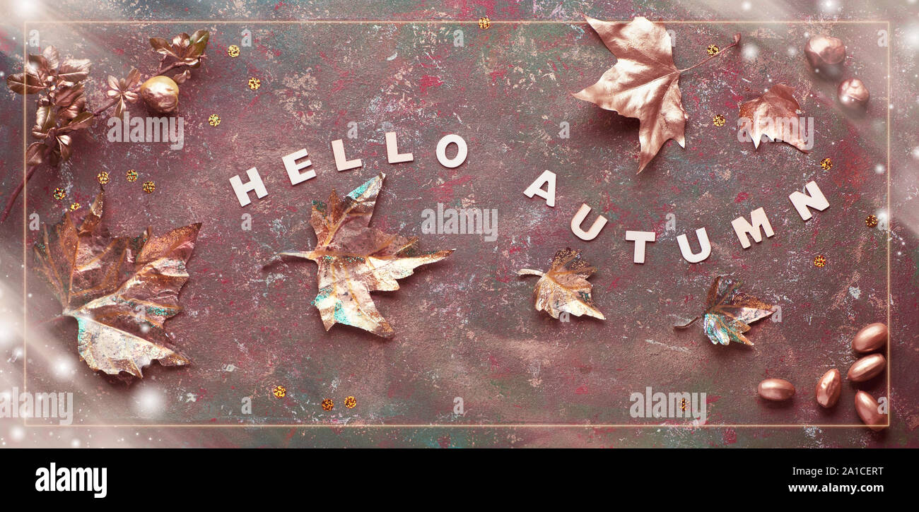 Mise à plat de l'automne avec les feuilles d'or peint et le texte 'Bonjour' sur bacgkrdound texturé vert foncé. Image panoramique tonique, la composition avec bannière Banque D'Images