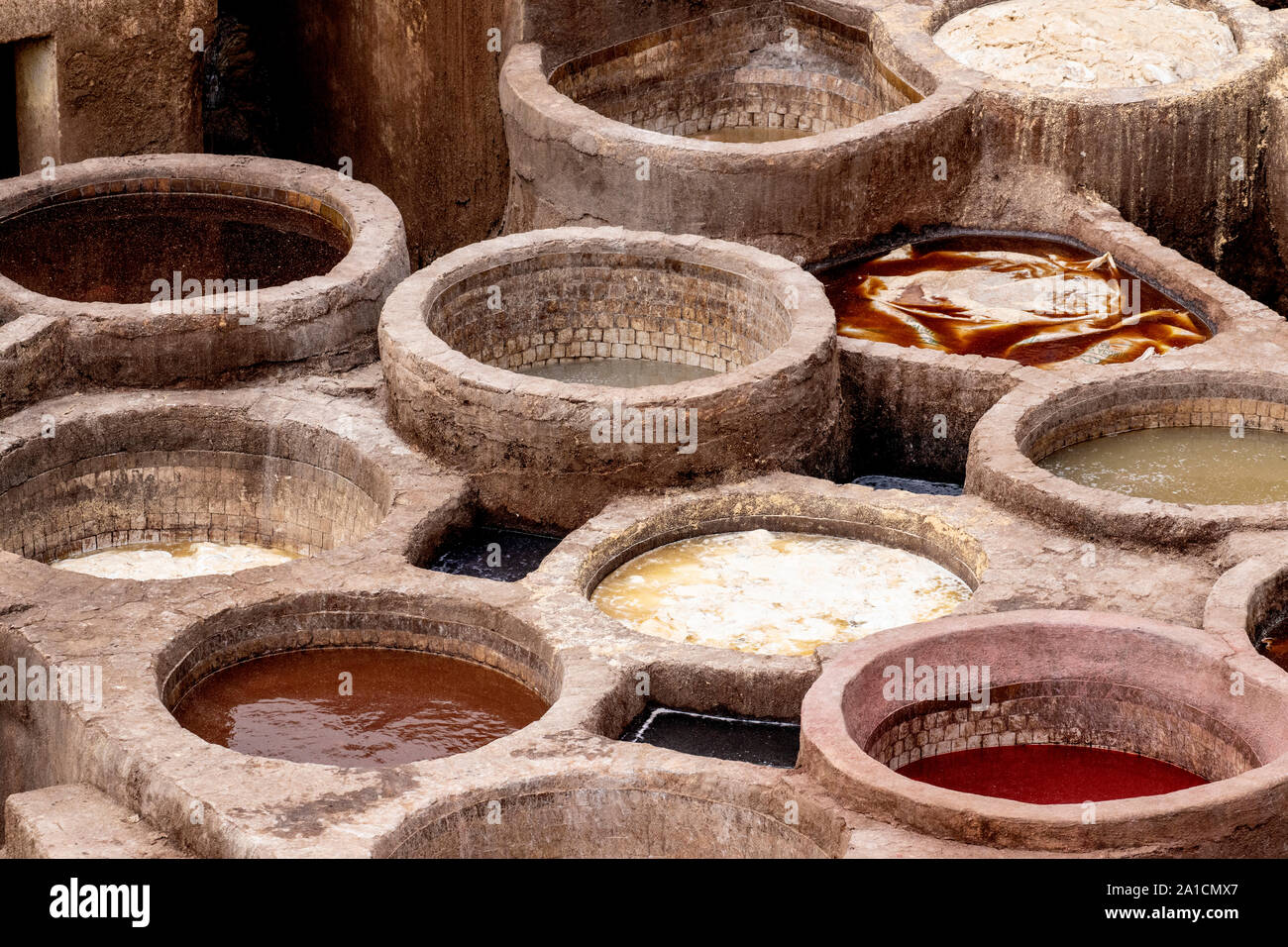 Cuves remplies de diverses teintures à une tannerie à Fes, Maroc, qui seront utilisés pour teindre les peaux différentes sonneries Banque D'Images