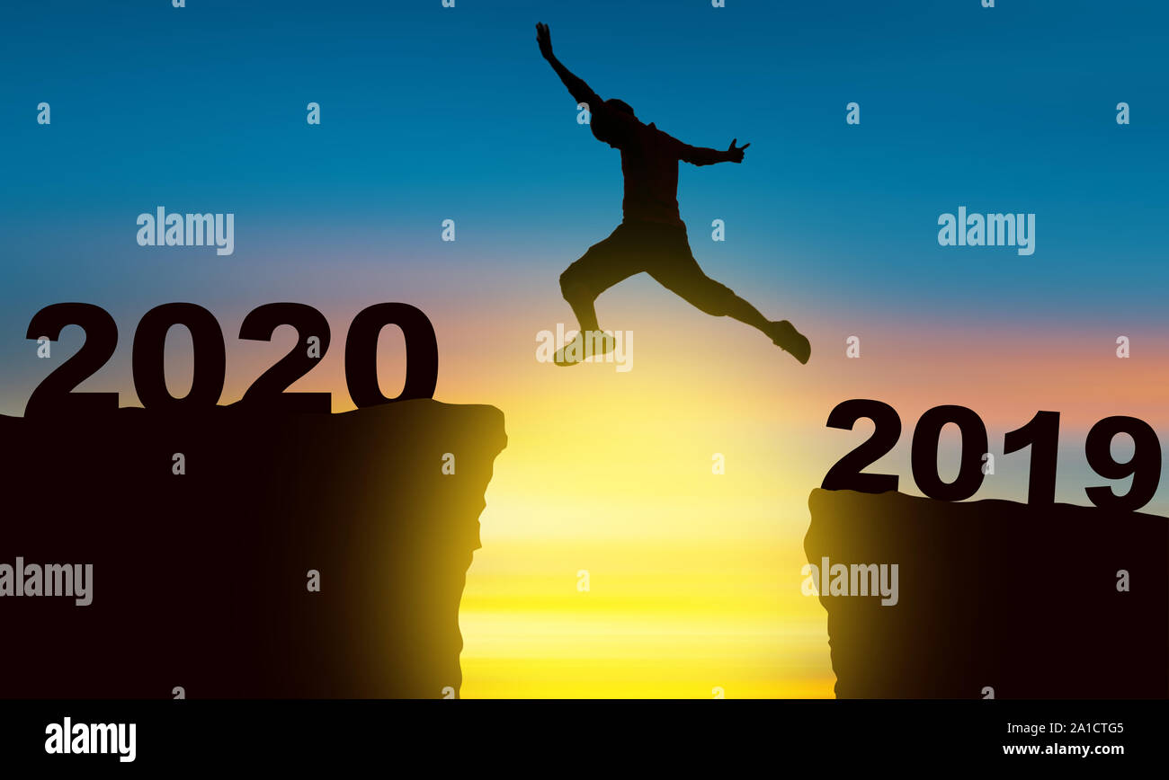Célébrer le nouvel an, Silhouette d'un homme sautant au-dessus de l'abîme au moment de le coucher de soleil Concept de victoire et succès Banque D'Images