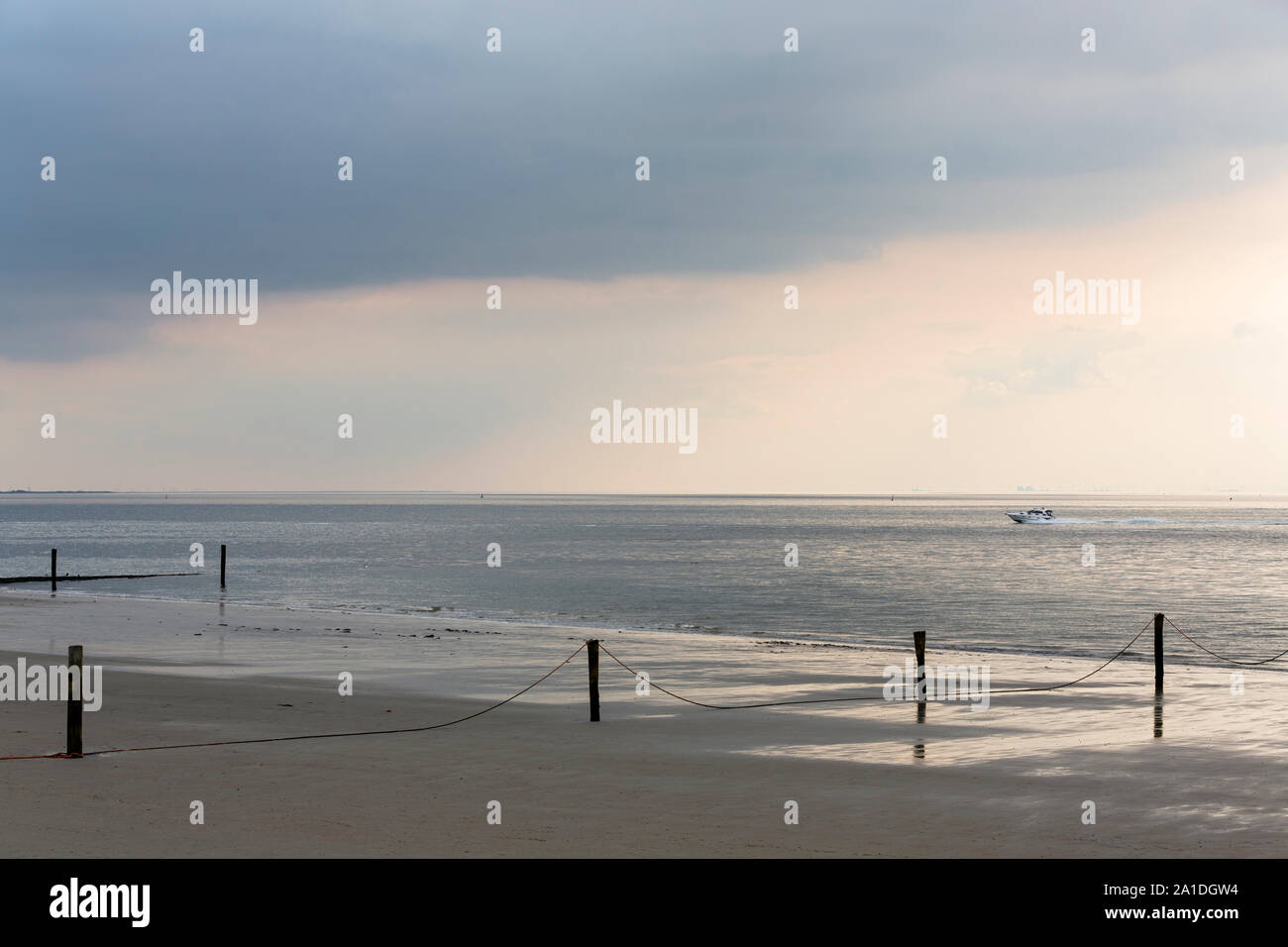 Norderney, Weststrand, Badestrand, Holzpfähle, Meer, Himmel, Regenwolken, Sonnenlicht, Boot Banque D'Images