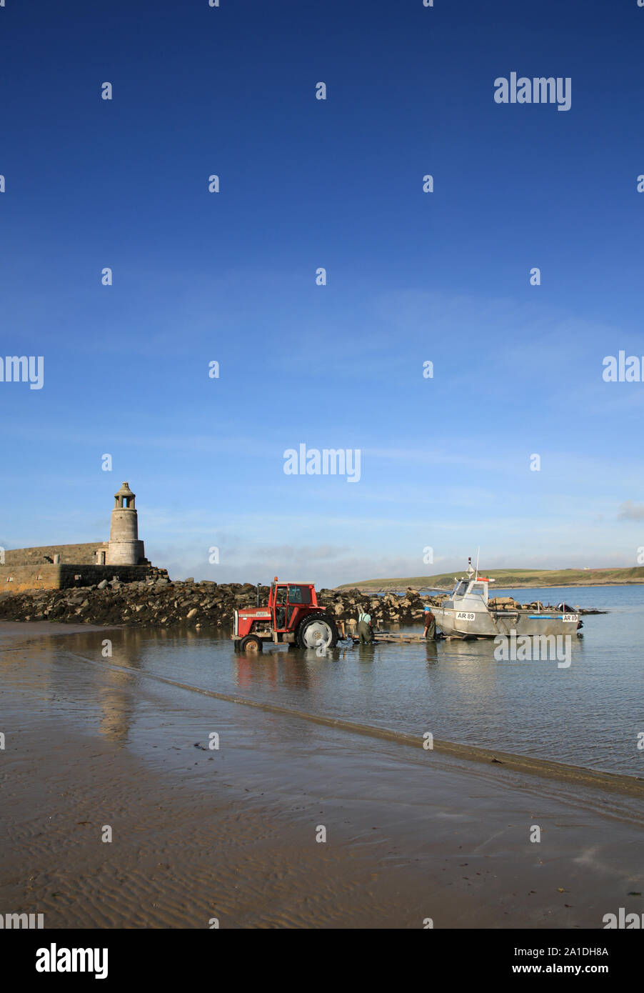 Bateau de pêche d'être tiré de la mer à Port Logan, Dumfries et Galloway, Écosse, Royaume-Uni. Banque D'Images