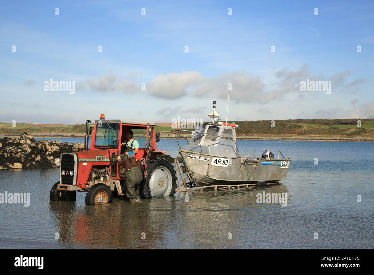Bateau de pêche d'être tiré de la mer à Port Logan, Dumfries et Galloway, Écosse, Royaume-Uni. Banque D'Images