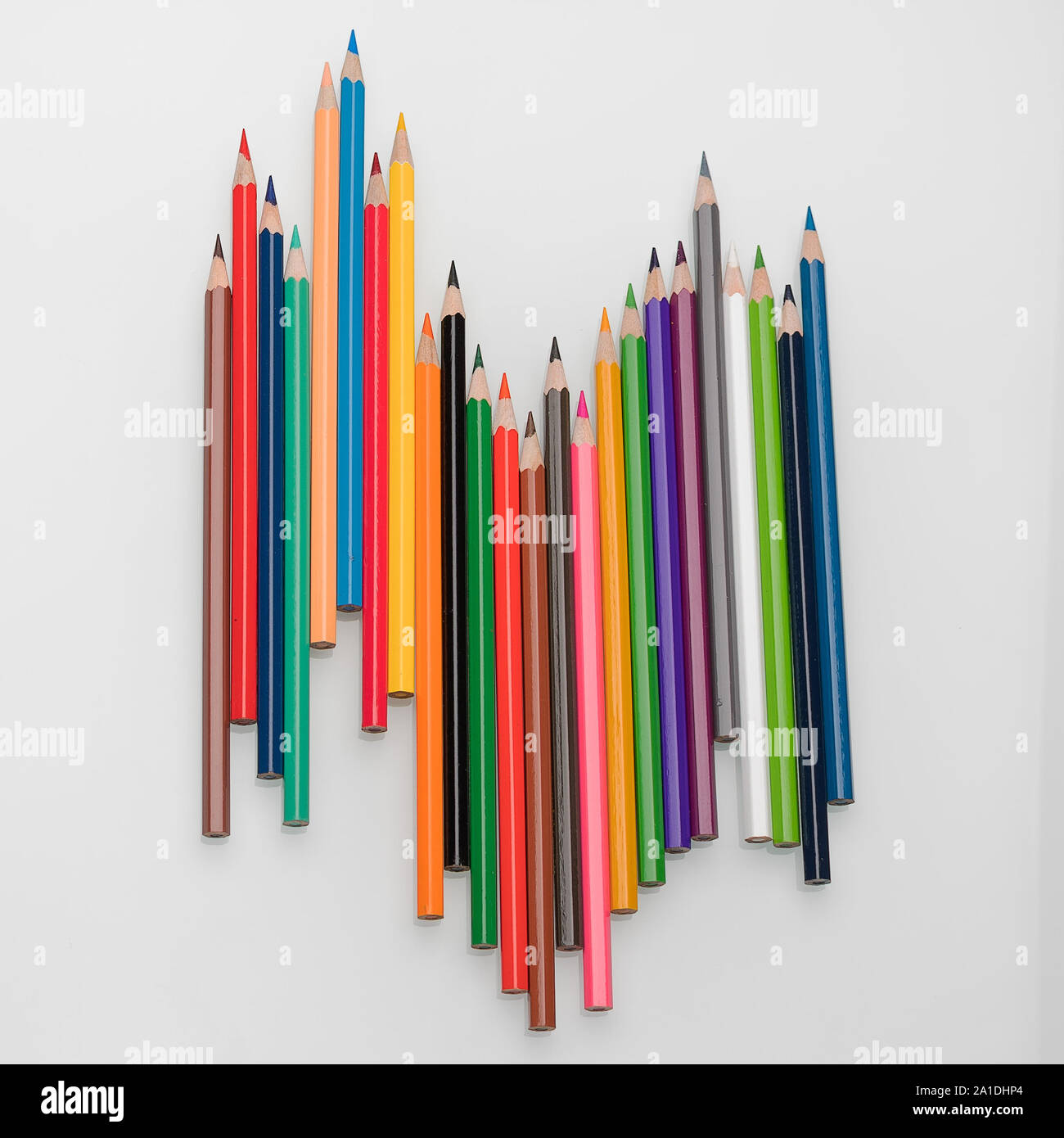 Crayons de couleur sous la forme d'une vague sur un fond blanc Banque D'Images