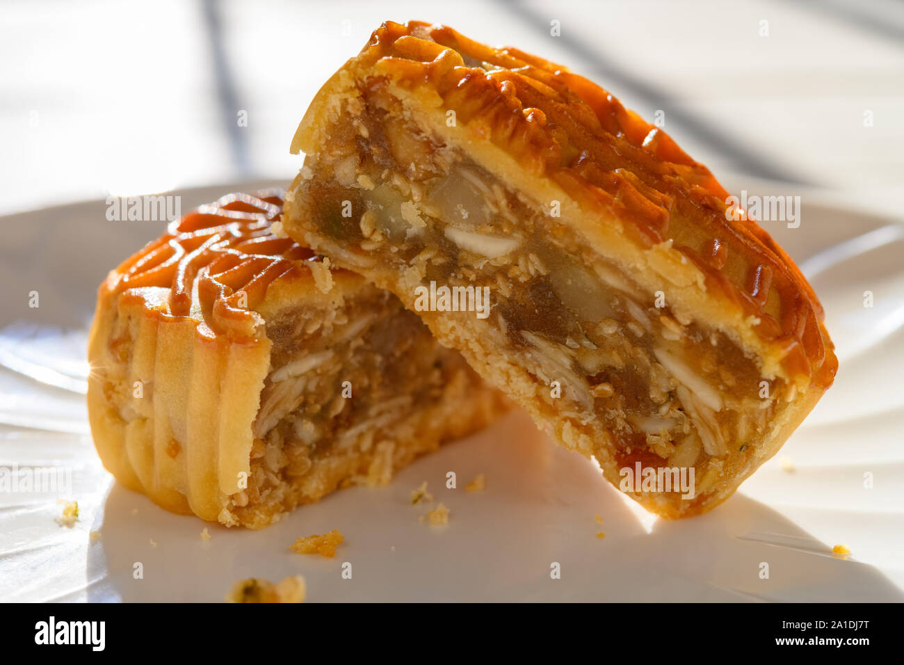Découper le chinois traditionnel mooncake dans un matin ensoleillé les Chinois sur les écrous moyens Banque D'Images