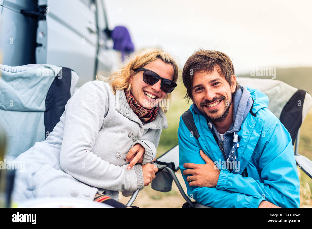 Young couple smiling avec camping, camping-car ou RV sur la plage. Heureux les jeunes gens en vacances avec camping camping-car, stationné sur une plage, voyager Banque D'Images