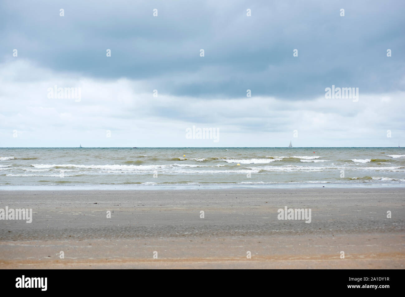 À l'ouest de la côte à Nieuwport, Flandre occidentale, Belgique. Mer du Nord dans l'arrière-plan avec des vagues et des nuages gris dans le ciel. Banque D'Images