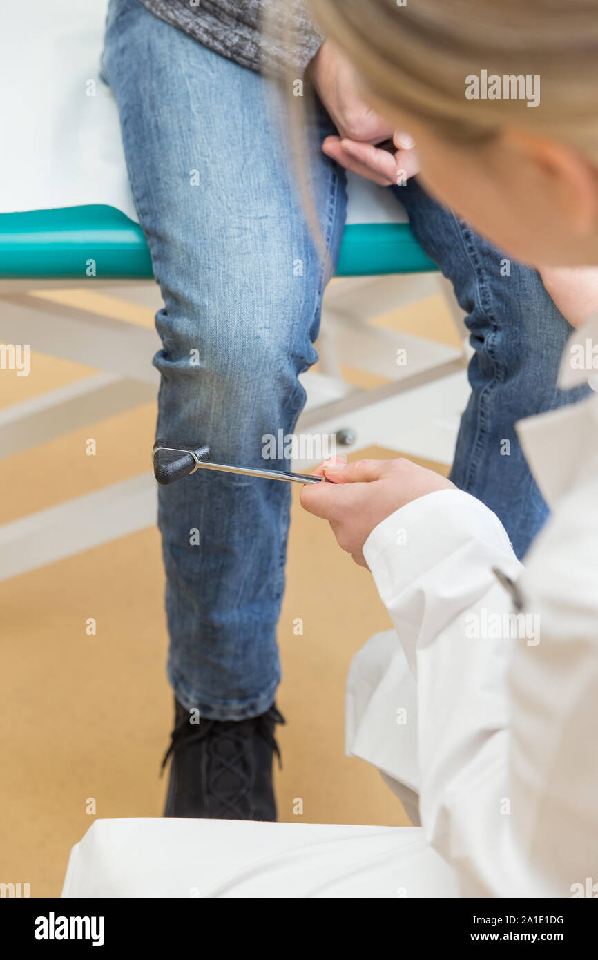 Femme médecin à percussion marteau et d'un patient de sexe masculin Banque D'Images