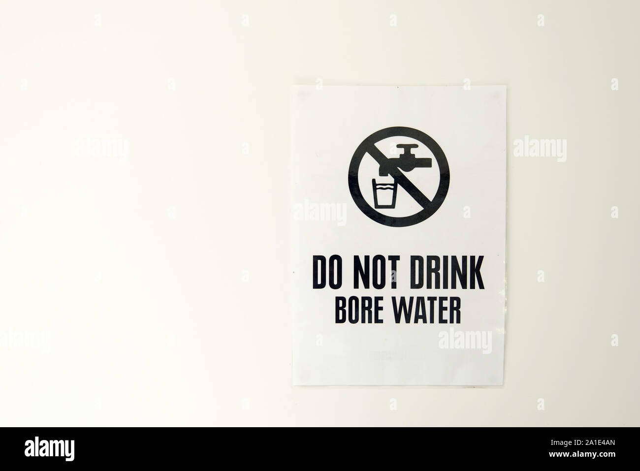 Un alésage de l'eau signe épinglé à un mur blanc avise la population de ne pas boire l'eau Banque D'Images