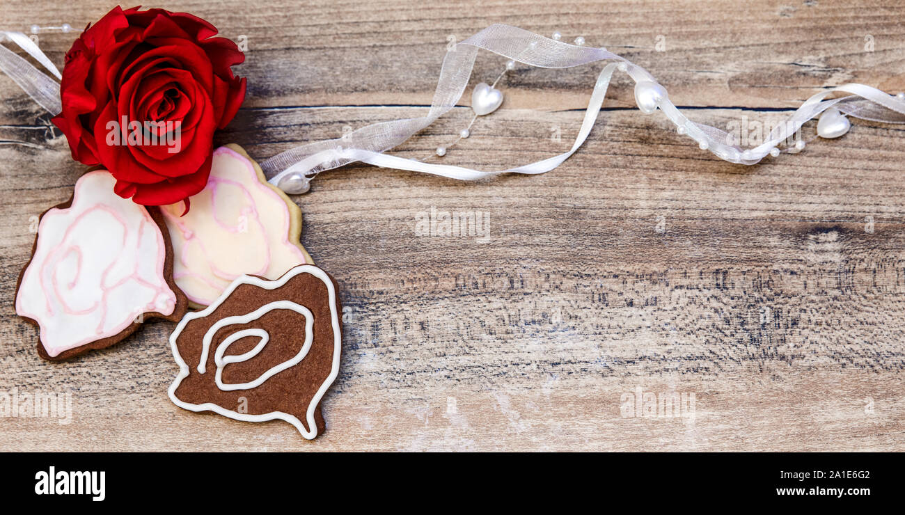 Cookies Rose, fleur rouge coeur sur table en bois avec copyspace Banque D'Images