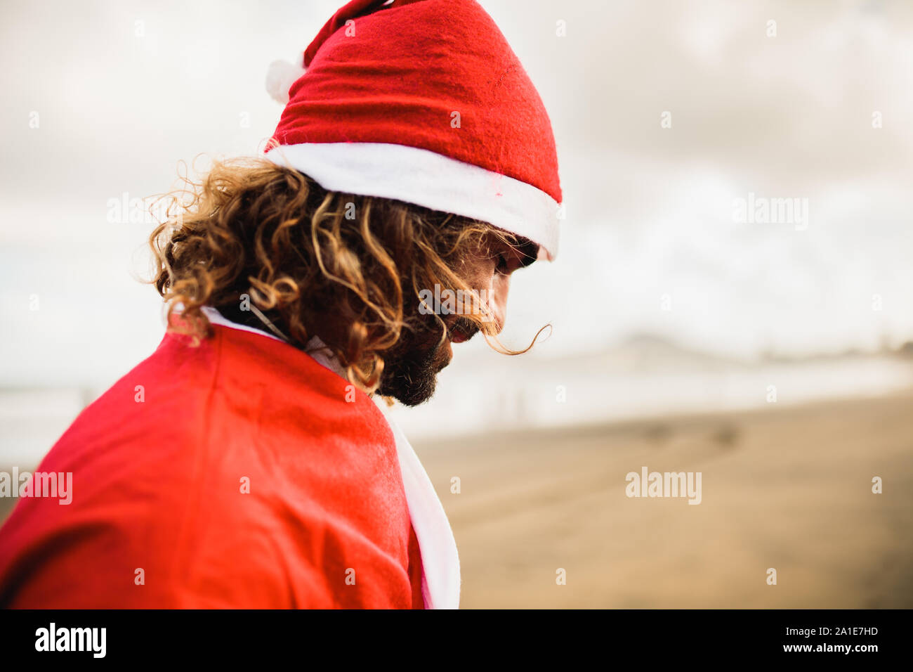 Jeune homme blond s'habille le Père Noël sur la plage Banque D'Images