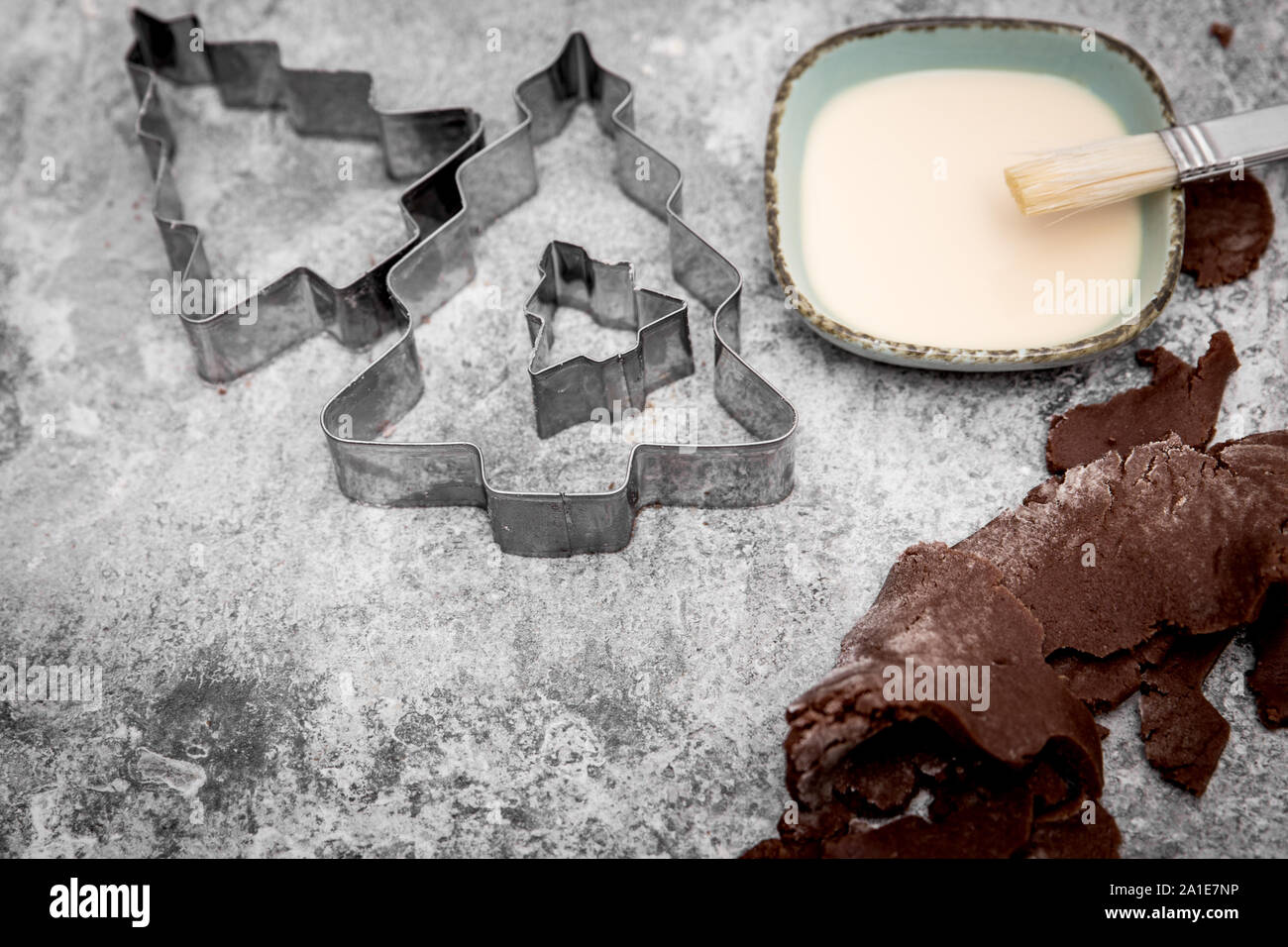 La pâte à biscuits au chocolat, arbre de Noël coupeurs, lait et oeufs sur fond gris Banque D'Images