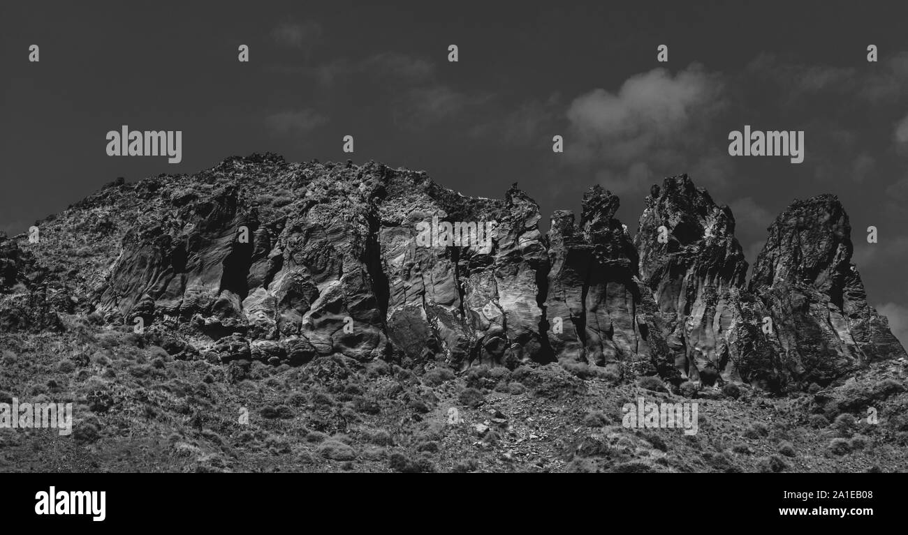 L'image monochrome Moody un basalte rock formation passant de l'île volcanique de Nea Kameni Banque D'Images